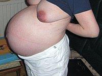 Schwangere Frau mit sehr dickem Bauch und schlaffen Milchtitten